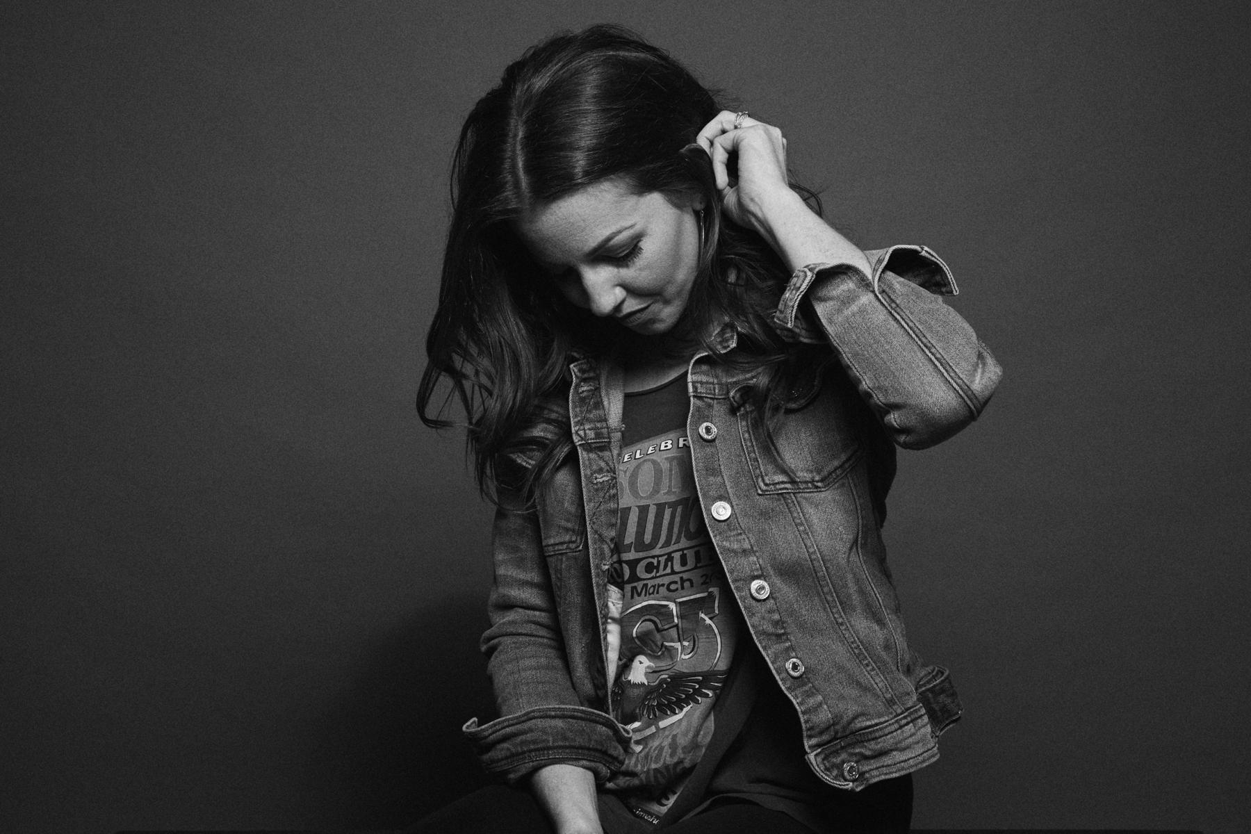 Shelby Rollins in a denim jacket, black and white studio portrait